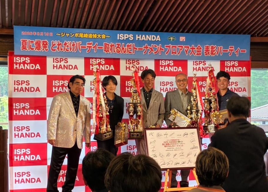 「～ジャンボ尾崎追悼大会～ ISPS HANDA 夏に爆発 どれだけバーディー取れるんだトーナメント プロアマ大会 表彰パーティー」の表彰式。優勝トロフィーを前に壇上に並ぶ蟬川泰果プロのチーム