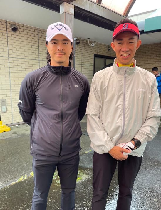 雨の大会会場で、石川遼プロと並んで写るMIWAの代表